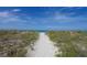 Sandy path leading to the beach, surrounded by natural dunes and vegetation at 1930 Harbourside Dr # 142, Longboat Key, FL 34228