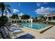 Community pool surrounded by lounge chairs, tables, and manicured landscaping at 1930 Harbourside Dr # 142, Longboat Key, FL 34228