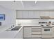 Efficient kitchen with white countertops, stove and ample storage, perfect for meal preparation at 1930 Harbourside Dr # 142, Longboat Key, FL 34228