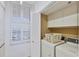 Laundry room including a side-by-side washer and dryer, and a window with shutters at 1930 Harbourside Dr # 142, Longboat Key, FL 34228