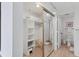 Walk-in closet including shelving, a mirrored door, and access to an en-suite bathroom at 1930 Harbourside Dr # 142, Longboat Key, FL 34228