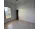 Well-lit bedroom featuring tile flooring, a window with blinds, and neutral paint at 2097 Wasatch Dr, Sarasota, FL 34235