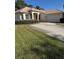 Inviting single-story home with a tile roof, lush lawn, and a paved driveway leading to the attached garage at 2097 Wasatch Dr, Sarasota, FL 34235