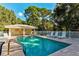 Outdoor pool area with plenty of lounge chairs, a sun umbrella, and a cabana at 2097 Wasatch Dr, Sarasota, FL 34235