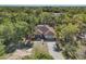 Beautiful aerial view showing the home nestled among mature trees with a long driveway leading to a two-car garage at 2301 Bern Creek Loop, Sarasota, FL 34240