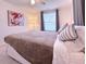 Bright bedroom with a modern art piece, window, and soft lighting at 240 Pocono E Trl, Nokomis, FL 34275