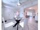 Bright dining area with a modern glass table, white chairs, and an open floor plan at 240 Pocono E Trl, Nokomis, FL 34275