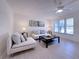 Spacious living room with modern furniture, coastal decor, large windows, and a ceiling fan at 240 Pocono E Trl, Nokomis, FL 34275