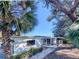 Rear exterior view of the home showcasing a covered patio and lush landscaping at 240 Pocono E Trl, Nokomis, FL 34275