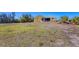 Expansive backyard featuring a yellow house surrounded by lush greenery and a blue sky overhead at 240 Spaniards Rd, Placida, FL 33946