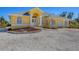 Stunning yellow home featuring beautiful landscaping, a well-manicured lawn, and a welcoming entrance at 240 Spaniards Rd, Placida, FL 33946
