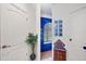 Bright hallway with a glass block window, potted plant, and hallway doors to rooms creating a welcoming space at 240 Spaniards Rd, Placida, FL 33946