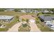 Aerial view of home showcasing a circular driveway, mature landscaping, and well-maintained lawn at 26506 Copiapo Cir, Punta Gorda, FL 33983