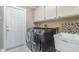 Laundry room with sink, washer, dryer, and overhead storage at 26506 Copiapo Cir, Punta Gorda, FL 33983