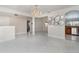 Spacious living room featuring tiled flooring, a decorative chandelier, and archways to other living spaces at 26506 Copiapo Cir, Punta Gorda, FL 33983