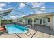Rear exterior view with screened in pool and tiled patio at 26506 Copiapo Cir, Punta Gorda, FL 33983