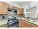 Well-lit kitchen featuring stainless steel appliances, granite countertops and stone backsplash at 2675 Pronto Ln, North Port, FL 34286