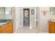 Hallway view of a well-lit bathroom with dual sinks and tile flooring at 391 Snapdragon Loop, Bradenton, FL 34212