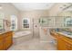 Luxurious bathroom featuring a soaking tub, a walk-in shower, and dual vanities at 391 Snapdragon Loop, Bradenton, FL 34212