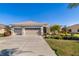 Inviting home with a three-car garage, green lawn, landscaping, and charming curb appeal at 391 Snapdragon Loop, Bradenton, FL 34212