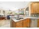 Bright kitchen with stainless steel appliances, island, breakfast bar, and views of the living area and pool at 391 Snapdragon Loop, Bradenton, FL 34212