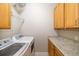 Laundry room featuring new appliances, wood cabinets, and granite countertops at 391 Snapdragon Loop, Bradenton, FL 34212