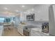 Close up of kitchen with white cabinets, stainless appliances, and view to living room at 420 Beach Rd # 502, Sarasota, FL 34242