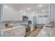 Bright kitchen featuring white cabinets, marble countertops, stainless steel appliances and an adjacent work space at 420 Beach Rd # 502, Sarasota, FL 34242