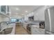 Modern kitchen with stainless steel appliances, white cabinetry, and view to open concept living room at 420 Beach Rd # 502, Sarasota, FL 34242