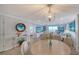 Open-concept living space with chandelier, dining table and ocean views through sliding glass doors leading to the balcony at 420 Beach Rd # 502, Sarasota, FL 34242