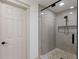 Updated bathroom showcasing a glass enclosed shower with pebble tile and a neutral color palette at 4646 Gleason Ave, Sarasota, FL 34242