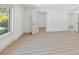 Bright bedroom with wood-look floors, large window and door to another room, with a peek of the bath at 4646 Gleason Ave, Sarasota, FL 34242