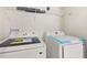 Convenient laundry room with modern Samsung washer and dryer units, complemented by overhead shelving at 4646 Gleason Ave, Sarasota, FL 34242