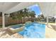 Sparkling pool and spa with a waterfall feature, surrounded by lush tropical landscaping and a privacy fence at 4646 Gleason Ave, Sarasota, FL 34242