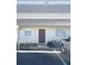 Exterior of condo featuring covered parking, a red door, and minimal landscaping at 507 Parkdale Mews # 507, Venice, FL 34285