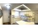 Bright kitchen with white cabinets, white appliances, and tile countertops at 507 Parkdale Mews # 507, Venice, FL 34285