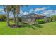 Well-maintained backyard with mature trees, screened-in lanai, and verdant lawn at 5562 Rain Lily Ct, Sarasota, FL 34238