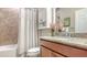 Well-maintained bathroom with a granite countertop, decorative flowers, and a bathtub with a shower curtain at 5562 Rain Lily Ct, Sarasota, FL 34238