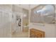 Elegant bathroom with a glass shower door featuring a heron design and a view of the walk-in closet at 5562 Rain Lily Ct, Sarasota, FL 34238