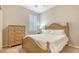Comfortable bedroom with a wooden bed frame, side table, and a window offering natural light at 5562 Rain Lily Ct, Sarasota, FL 34238