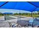 Patio area with a covered bocce ball court, surrounded by lush landscaping and comfortable seating areas at 5562 Rain Lily Ct, Sarasota, FL 34238