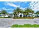 Stunning clubhouse with manicured landscaping, palm trees, and circular driveway at 5562 Rain Lily Ct, Sarasota, FL 34238