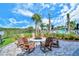 Cozy outdoor fire pit with seating surrounded by lush landscaping and a view of the pool at 5562 Rain Lily Ct, Sarasota, FL 34238