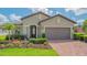 Attractive front entrance featuring an elegant front door, columns, and beautiful landscaping at 5562 Rain Lily Ct, Sarasota, FL 34238