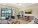 Comfortable living room with view of screened lanai, pool, and lake at 5562 Rain Lily Ct, Sarasota, FL 34238