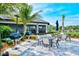 Outdoor dining area with multiple seating areas, a barbecue, and well-maintained landscaping at 5562 Rain Lily Ct, Sarasota, FL 34238