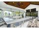 Well-equipped outdoor kitchen and bar area with multiple seating options, perfect for entertaining at 5562 Rain Lily Ct, Sarasota, FL 34238