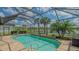 Gorgeous pool with a screened-in lanai and scenic views of the lake and lush landscaping at 5562 Rain Lily Ct, Sarasota, FL 34238