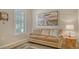 Cozy sitting area with a comfortable couch, decorative pillows, and natural light from a window at 5562 Rain Lily Ct, Sarasota, FL 34238