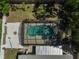 Aerial view of the backyard featuring a screened-in pool, landscaped yard, and a cozy fire pit area at 5611 22Nd E St, Bradenton, FL 34203